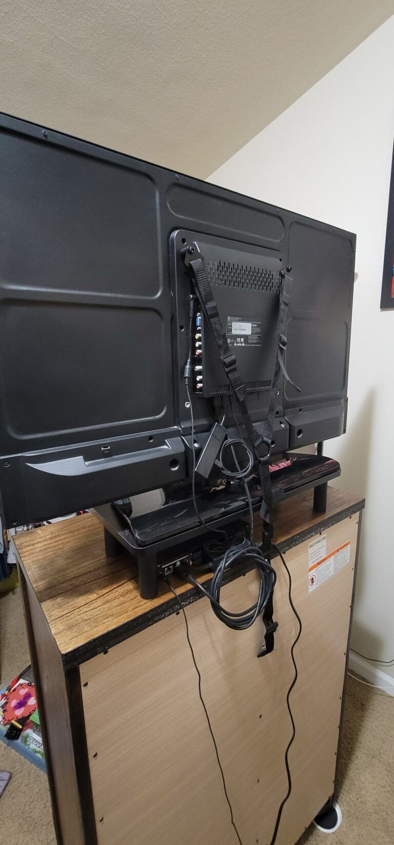 Child's TV put on a riser and safety strapped to their dresser. TV Mounting Service.
